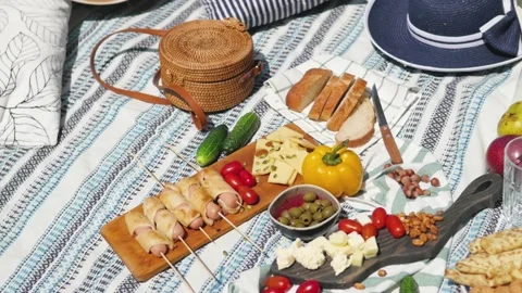 Summertime picnic setting on the grass with open picnic basket, fruit, salad and Stock-Footage 147111429