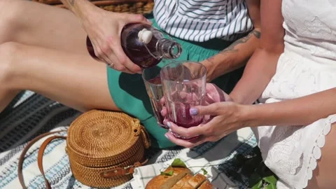 Summertime picnic setting on the grass with open picnic basket, fruit, salad and Stock Footage 147111463