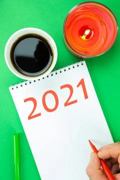 Summing up the results of 2021. Open notebook, a man's hand and a glass with  Foto stock