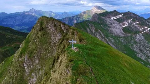 Summit cross on dramatic alpine ridge aerial drone view Fotos de archivo