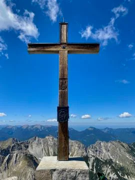 Summit cross of Soiernspitz, mountain view over peaks, blue sky, Bavaria Stock Photos