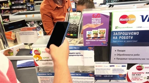 SUMY, UKRAINE - AUG 13, 2018: Customer paying with apple pay by mobile phone on Stock Footage