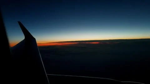 The sun about to rise beneath the horizon above the clouds Stock-Fotos