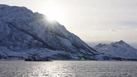 Sun is about to set behind a snowy mountain in Norway Vídeo Stock 267808050