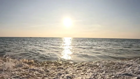 A sun above calm waves on a sandy beach Stock Footage 327207532