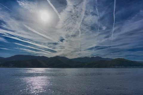 Sun and blue sky with dramatic cloudscape over Elba island Stock Photos