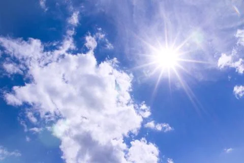 Sun and clouds in blue sky Stock Photos