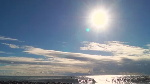 Sun and clouds over the sea and the wave that hits the rocky shore Stock Footage 169810441