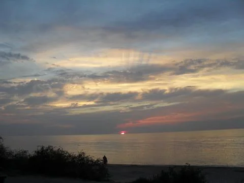 Sun and clouds at sunset Stock Photos