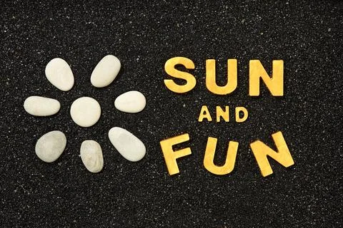 Sun And Fun - Words in black beach sand Stock Photos