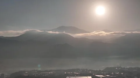 Sun and Low Clouds Above Layered Mountain Silhouettes Vídeos de archivo 347497604