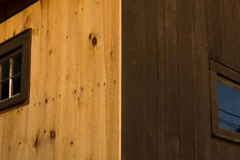 Sun and Shadow Creating Dark and Light Side of Wood Paneled Home Stock Photos