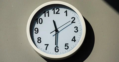 Sun and sky reflecting on clock face. Time lapse on a modern white Clock Video stock 167575528