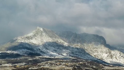 Sun and snowy clouds over the mountains, time lapse Stock Footage 70248978