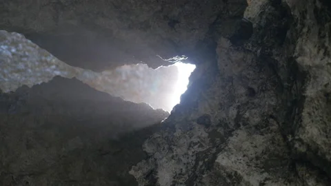 The sun and the spray passes between two rocks and dazzles us, in Indonesia Stock Footage 222365539