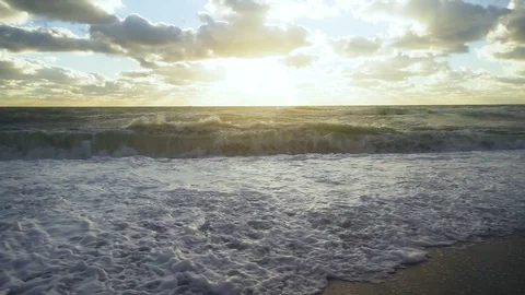The sun and sunrays illuminate the stormy ocean slow motion Stock Footage 82317152