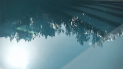 Sun and tree reflections in turquoise blue water pool Stock Footage 114528380