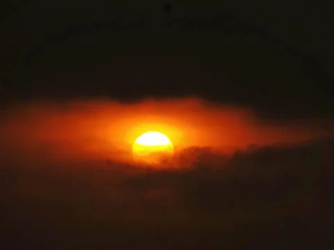 The sun appears among dark clouds Stock Photos
