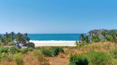 Sun beach sand surfer waves palms in Puerto Escondido Mexico. Stock Footage 259821633