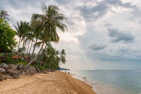 Sun beam breaks through the clouds above the tropical beach Stock Photos