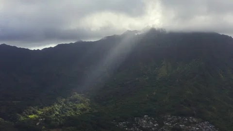 Sun beam pierces through clouds, illuminating patch of tropical forest, Hawaii Stock Footage 126602319
