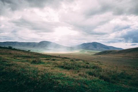 Sun beam through clouds on grass field Stock-Fotos