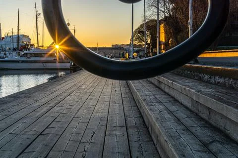 Sun beams glaring at sunset with a reflection on the edge of iron fence Stock Photos