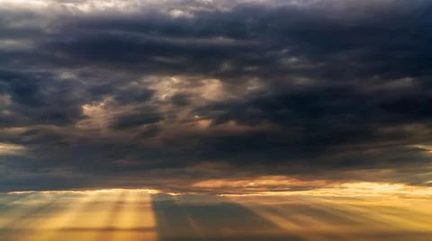 Sun beams or rays breaking through the dark clouds at sunset. Beautiful spect Foto stock