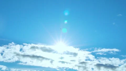 Sun with beams sun rays sunlight above plump white clouds in clear blue sky time Stock Footage 314648669