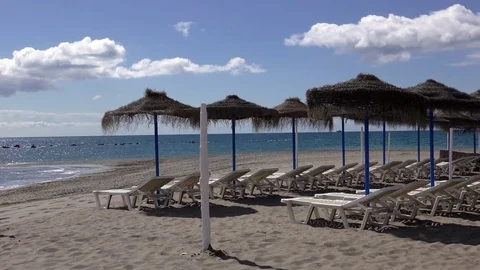 Sun beds parasols blue sky ocean Stock Footage 74652702