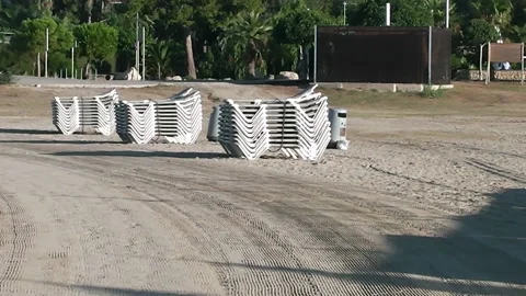 Sun beds on a stack on golden sandy beach. Stock Footage 152683826
