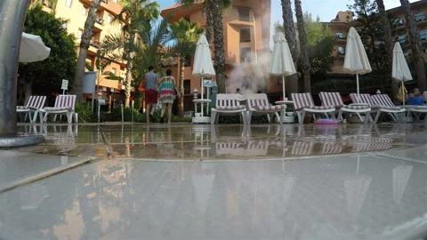 Sun beds with umbrellas by the pool on site Stock Footage 128548469