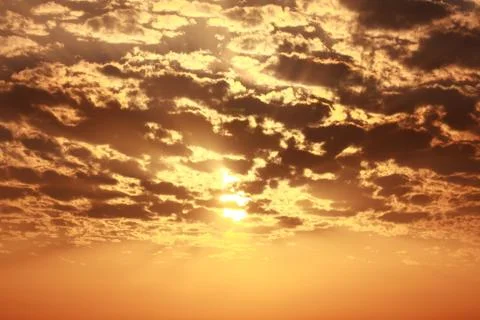 Sun behind cloud orange warm sky Stock Photos