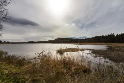 Sun behind clouds over lake, Gjennestadvannet, Stokke, Vestfold in Norway Stock Photos