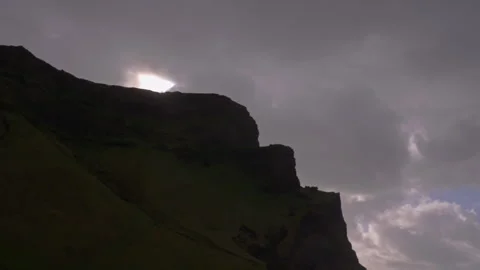 Sun behind clouds over reynisfjara beach mountains at dusk Video stock 329442609