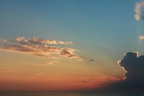 Sun behind the clouds shining on blue sky. Colorful view. Inspiration. Stock Photos