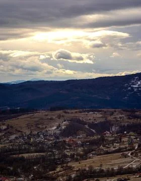 The Sun behind the clouds in winter in the mountains Stock Photos