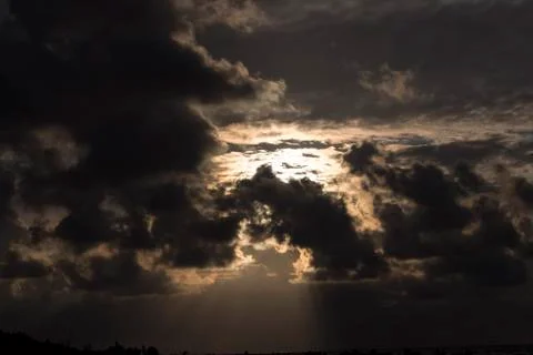 Sun behind dark clouds. Stock Photos