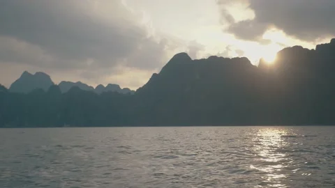 The Sun Behind Mountain In Evening Toss Boat Floating in Dam National Park Stock Footage 154016915