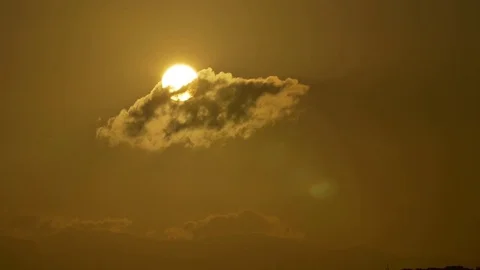 Sun behind a small cloud Stock Footage 77803712