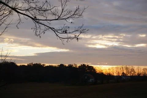 Sun from behind tree line Stock Photos