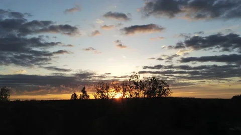 Sun behind trees in sunset - Drone camera moves up Stock Footage 137865505