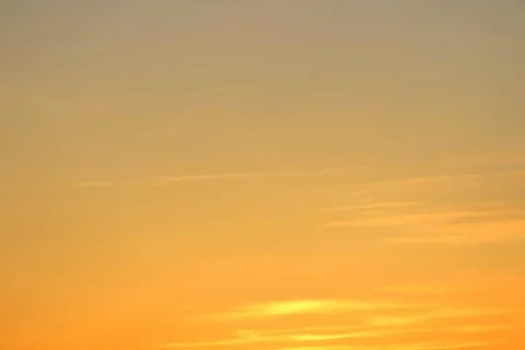 Sun below the horizon and clouds in the fiery dramatic orange sky at sunset or Foto stock