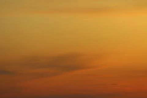 Sun below the horizon and clouds in the fiery dramatic orange sky at sunset or Foto stock