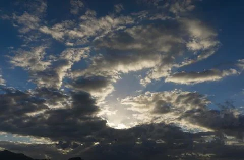 Sun between clouds on cloudy day. Stock Photos