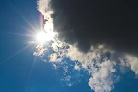 The sun between the dark cloudy clouds Stock Photos