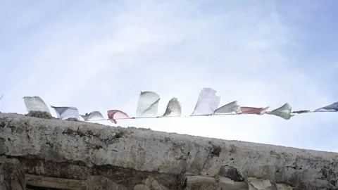 Sun Bleached Tibetan Prayer Flags Fluttering in Wind Against Sky Stock Footage 345631865