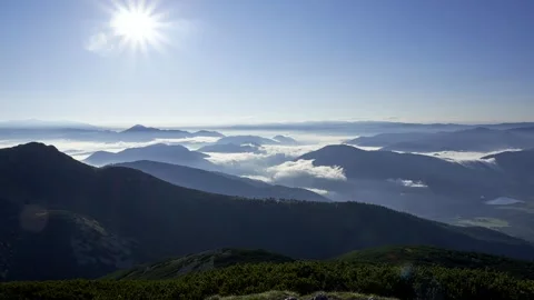 The sun in the blue sky over the mountains, the landscape in the valley covered Video stock 251855168