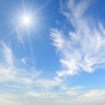 Sun on blue sky with white clouds Stock Photos