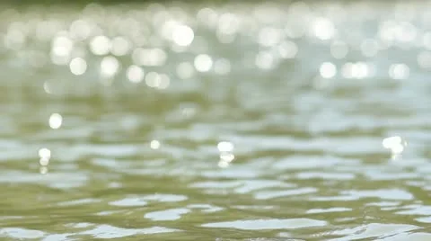 Sun bokeh reflections off lake water waves  in park Stock Footage 11250250
